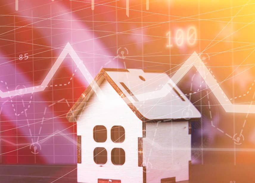 Un modèle de maison miniature recouvert de graphiques colorés et de données numériques, symbolisant l'analyse du marché immobilier.